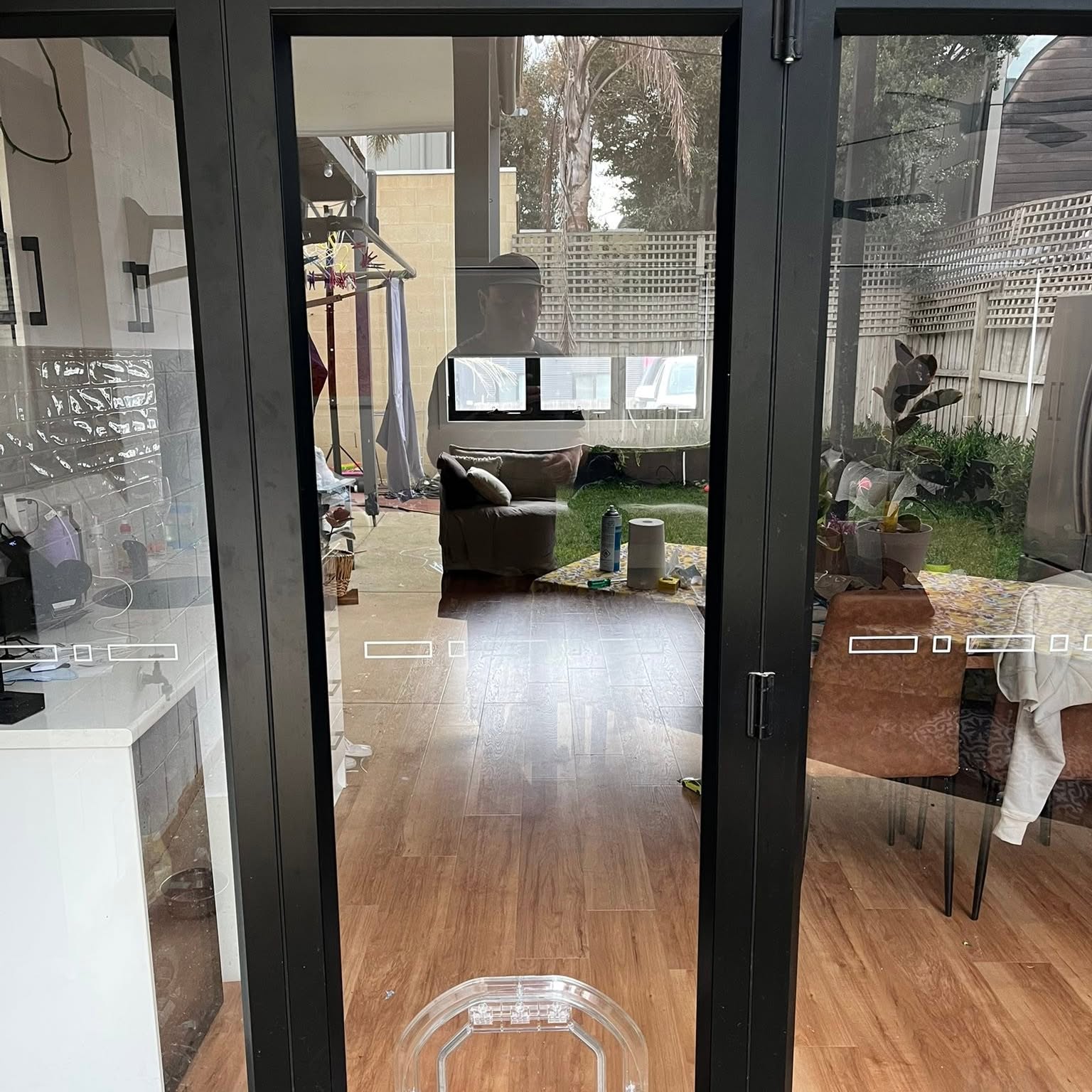 A pet door fitted into black framed bifold doors, photographed from inside during the job